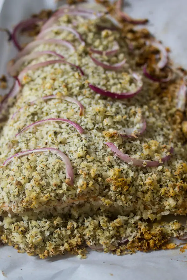 baked mediterranean crusted salmon on a baking sheet.