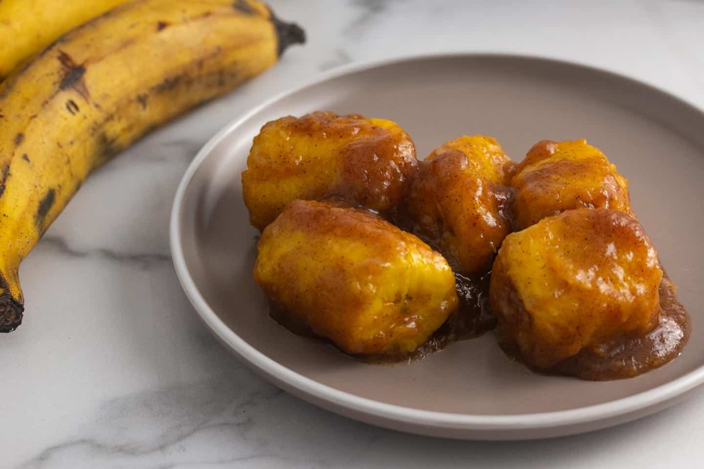 plátanos en tentación servidos en un plato redondo.