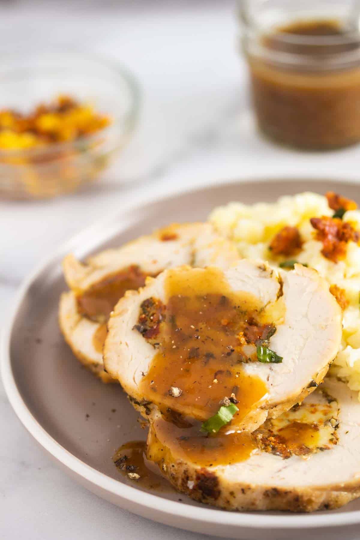 Stuffed turkey breast served with mashed potatoes on a round plate